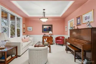 Beautiful architectural details, including tray ceilings and wainscoting, enhance the home’s charm, while expansive windows flood the space with natural light.