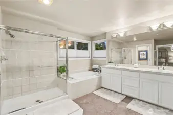 Elegant primary bathroom includes a soaking tub, separate shower, water closet, and dual sinks with generous storage.
