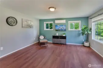 Bright, stylish, and move-in ready! This living space features rich wood flooring, a mini-split for year-round comfort, and fresh paint with a modern accent wall. Natural light fills the room—perfect for relaxing or entertaining.