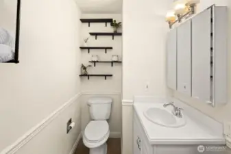 Bathroom makes great use of space with mirrored storage and lots of shelving.