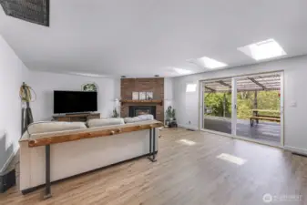 Large living room with anchoring fireplace and large slider to back deck.
