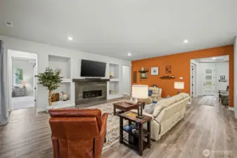 A spacious and welcoming living room anchored by a beautiful fireplace and custom built-ins, creating the perfect spot to relax, gather, and feel right at home.