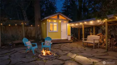 Tucked into a quiet corner, a cheerful butter-yellow playhouse adds a touch of storybook charm. Gather 'round the firepit, roast marshmallows and share stories.