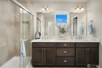 Luxurious Primary Bathroom, features maple cabinets, quartz countertops, dual sinks, tile shower and double sided walk-in closet.