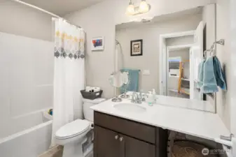 2nd Bathroom on top floor features maple cabinet, quartz countertop, stylish light fixtures, soaking tub & shower.