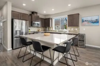 Kitchen features maple cabinetry, stylish quartz countertops, engineered hardwood floors and stainless steel appliances.  Kitchen windows overlooks naturally landscaped side yard.