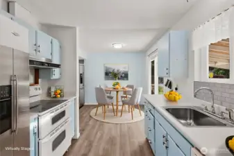 Kitchen features updated LVP flooring and a spacious walk-in pantry and utility room. All appliances stay.