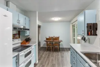 Kitchen features updated LVP flooring and a spacious walk-in pantry and utility room. All appliances stay.