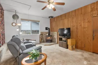 Additional living space with a gas fireplace and fan.