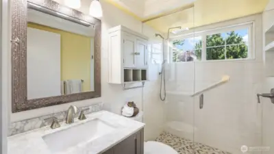 Beautiful updated 3/4 bath en suite in this primary offers a tile surround walk-in shower and windows to allow natural light to shine through.