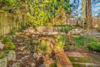 Terraces, woods, garden space and brick patios wrap around the home.