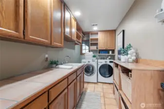 Main floor laundry with a handy sink, lots of counter space for folding and plenty of storage.