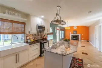 Large kitchen with island, opens to family room and out the door to covered patio. Door to the right goes into laundry room and steps down to garage.