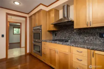 Stainless appliances include double ovens, gas cooktop, range hood and dishwasher.