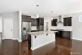 Garage entry door just off of the Chef kitchen with Granite Cooking Island, separate cook top, stainless appliances, all perfect for entertaining guests!
