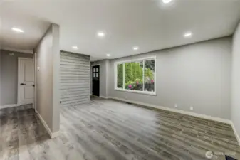 The room’s neutral palette, durable vinyl plank flooring, and custom shiplap accent wall