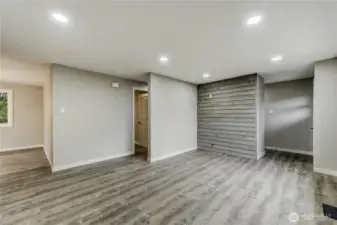 Modern and move-in ready, this inviting living room highlights custom touches like a wood-paneled accent wall and recessed lighting throughout.