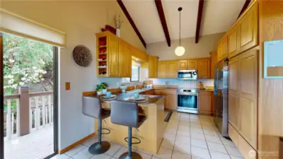 Gourmet kitchen with solid oak upper cabinets, granite tile counters, tile floors, and a built-in pantry.