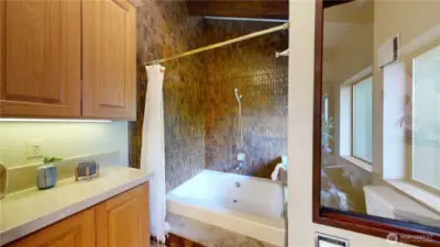 The full bath includes a tiled tub/shower with rich wood-toned surround, creating a cozy spa-like feel just steps from the primary suite.