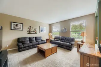 BRIGHT AND INVITING LIVING ROOM HAS PLENTY OF SPACE FOR FURNITURE, AND ABUNDANT NATURAL LIGHT.