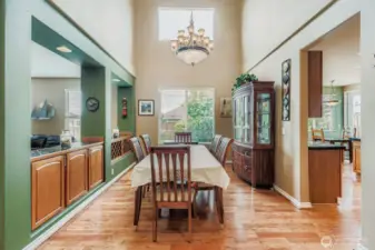 GRACEFUL DINING AREA WITH SOARING VAULTED CEILINGS AND SHINNING HARD WOOD FLOORS.