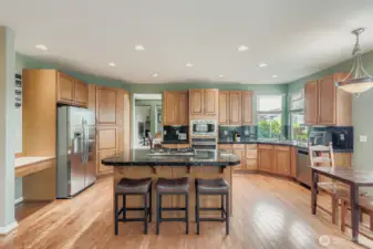 ELEGANT KITCHEN WITH QUALITY CABINETS, STONE COUNTERS, & SERVING ISLAND.