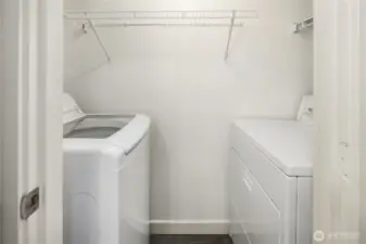 Laundry room in unit, in the bathroom. New top load washer machine, with convenient racks for storing everything you might need.