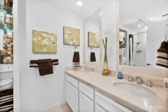 Hall bathroom with dual sinks, marble countertops, marble floors, shower/tub combo