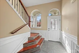 Foyer with a sneak peak at the shadow box wainscoting and crown molding that is seen throughout the home