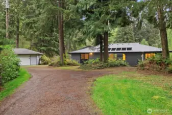 The detached garage is to the left, exterior of the home is well maintained.