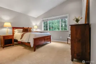 Primary bedroom has vaulted ceilings, new carpet, and plenty of natural light.