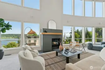 2 story living room with soaring ceilings & walls of glass framing the lake & mountain views beyond