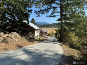 Private driveway runs along the south boundary line, past the storage building to arrive at the Cottage located in the southeast corner of the 2 acre parcel. View tot he east.