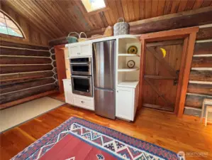 Local fir milled on-island and installed by locals. Custom cabinetry and "moon" door designed and built by local craftsman, Brian Himlan. Door accesses the guest bath and laundry.