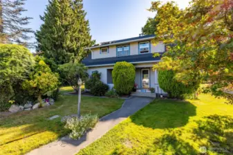 Mature landscaping offers privacy and shade, while a covered front porch greets you.