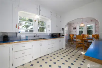 Vintage charm everywhere!  Original cabinetry offers lots of storage.  Tons of counter space.  Another arched doorway leads to the breakfast nook.