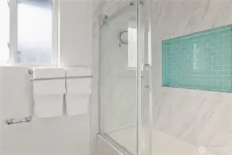Hall bath with glass tub/shower enclosure with large tile niche.
