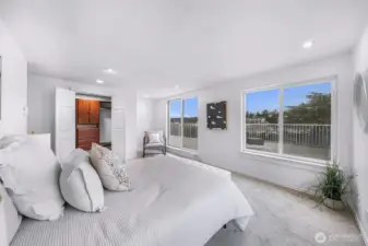 Primary bedroom with walk-in closet, ensuite bath, and direct deck access.