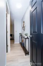 Stepping through the front door, you’re welcomed by a bright, refreshed entry hallway that immediately feels clean and move-in ready. The luxury vinyl plank flooring runs seamlessly through the space, adding durability while keeping the aesthetic modern and cohesive. Neutral wall tones make the area feel open and light, while the darker door finish provides contrast and visual interest. There’s enough wall space for a console table, artwork or a drop zone setup, making the entry both functional and welcoming. It’s the kind of hallway that quietly signals the home has been cared for — tidy, updated and ready for everyday life.