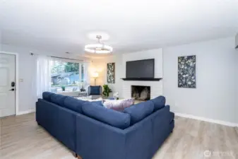 Looking back toward the entry, you can see how the living area connects effortlessly with the rest of the home. The open sightlines make the space feel larger while still maintaining cozy definition around the fireplace wall. The flooring continuity ties everything together visually, and the neutral palette makes it easy for any style of furniture or décor to fit right in. It’s a flexible space that works just as well for quiet nights as it does for hosting.
