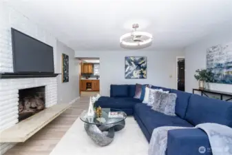 This closer view of the fireplace wall highlights one of the home’s character features. The painted brick gives a clean, refreshed look while maintaining that timeless charm only real masonry brings. The hearth offers styling or seating options, and the TV placement above keeps the room functional without sacrificing aesthetics. It’s a comfortable anchor point that naturally draws people in.