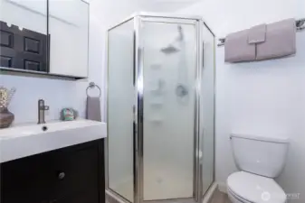 This bathroom features a standalone shower enclosure, offering a more private and efficient bathing setup. The glass doors keep the space feeling open rather than boxed in, while the vanity provides storage and counter functionality. Updated fixtures and clean finishes make the space feel refreshed and practical. Ideal for guests or multi-person households, it adds convenience without sacrificing comfort.