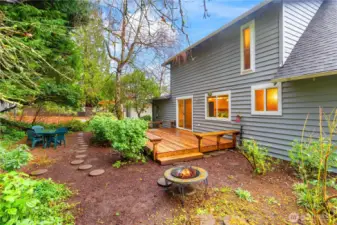 Fully fenced backyard features a native plant garden, fire pit, and deck