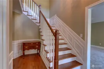 Grand staircase with wainscoting and note the additional wainscoting in the entry hall