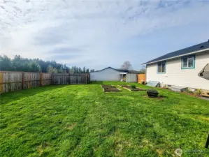 Garden boxes and rear of workshop shown.
