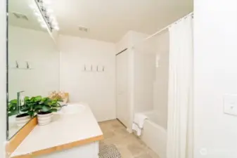 The main bath features ample counter and cabinet space for storage, a luxurious soaking tub for relaxation, and a convenient linen closet for added organization.