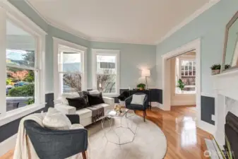 This lovely living room features gorgeous period moulding, large windows providing plenty of natural light, gas fireplace insert with marble surround and elegant mantel. Large doorway leads to dining room and has a pocket door for privacy.