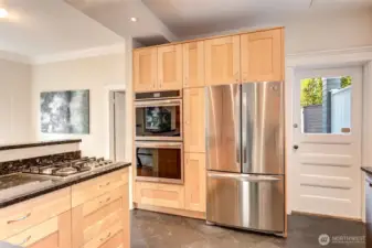 Kitchen opens to dining room for ease of entertaining. Birch cabinets provide plenty of storage. Granite countertops. Stainless steel appliances, including new double ovens and dishwasher. Heated slate floors. Door leads to the back deck.