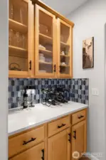 Between the kitchen and the formal dining room is the Butler's Pantry. Glass cabinets, quartz counters and plenty of storage. Across from this is a pantry closet.