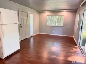 Living room with windows on 3 sides plus a sliding door out to a small deck.